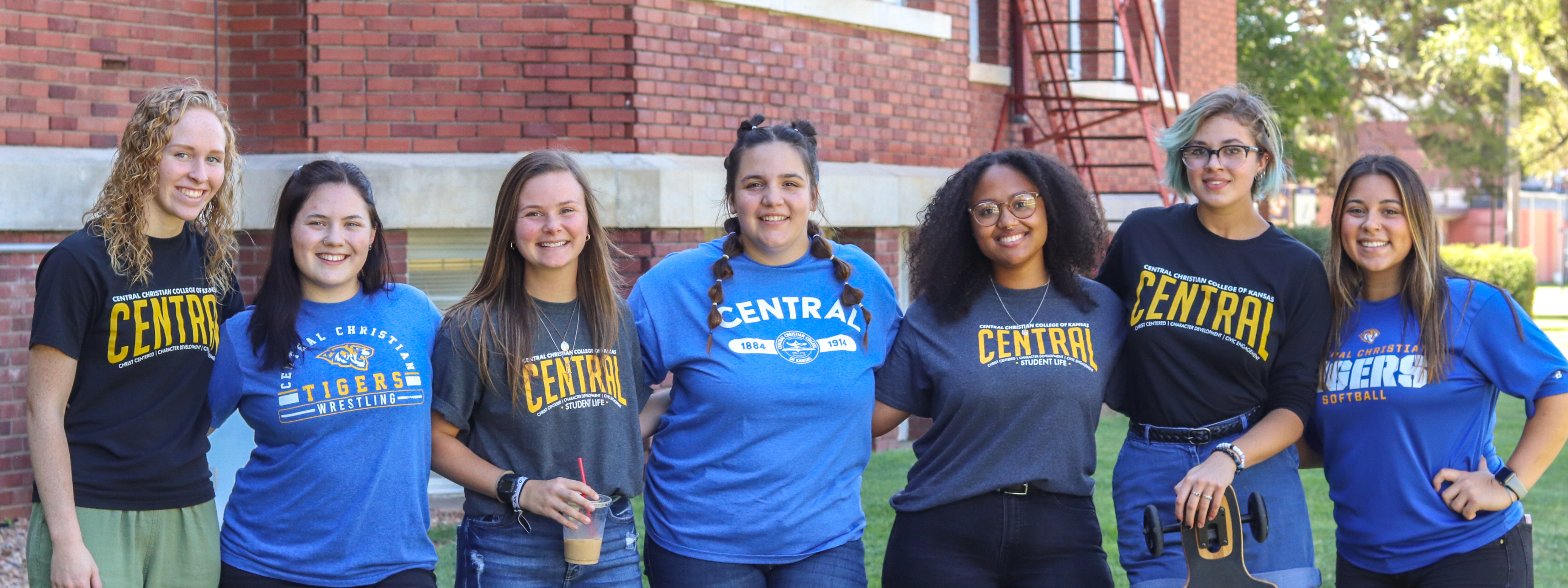Education Central Photo Header: girls standing in a line wearing Central gear and smiling