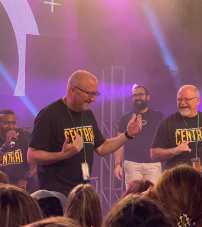 Photo of Bishop Cowart and Bishop Whitehead dancing in black Central shirts at the FMYC conference in 2022