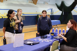 Three Central students listen to a representative talk about her company.